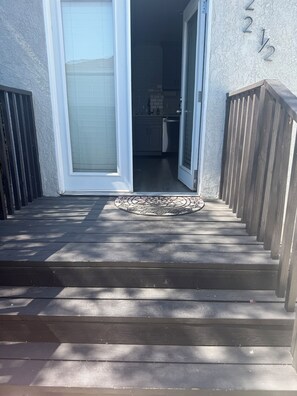 A wooden staircase leading to a door with a glass panel, a tiled wall, and a number '2 1/2' sign. - Bright & Modern Bixby Knolls Studio + In-Unit W/D (Long Beach)