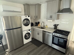 A modern kitchen with stainless steel appliances, a dishwasher, a sink, and a stove. - Bright & Modern Bixby Knolls Studio + In-Unit W/D (Long Beach)