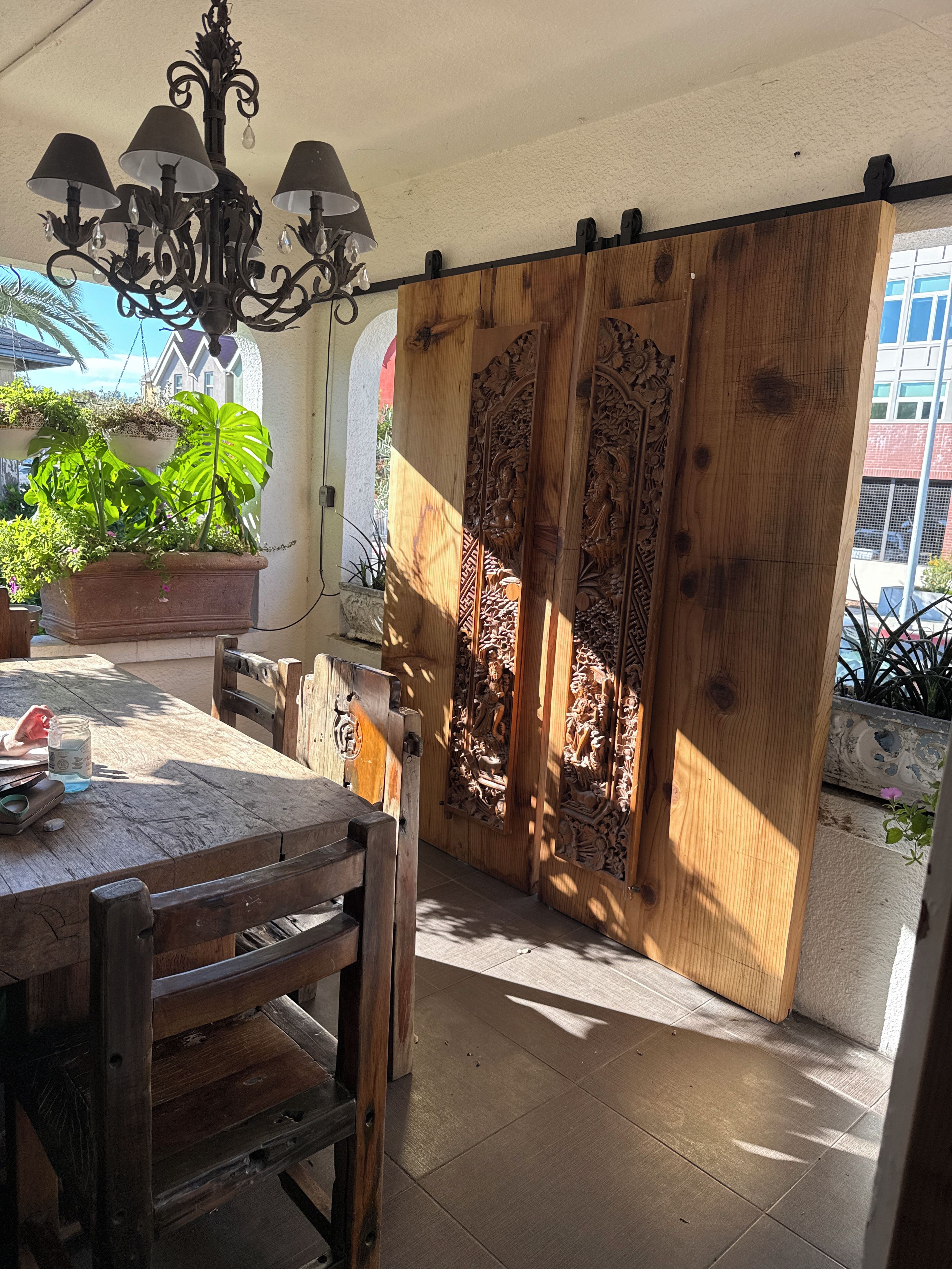 Una mesa de madera con sillas, una araña y una planta en maceta.