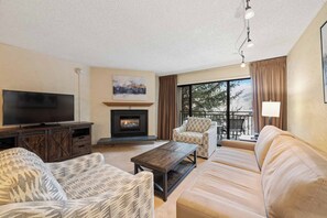 Una sala de estar con chimenea, televisión y sofá.