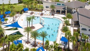 A large outdoor swimming pool surrounded by palm trees and lounge chairs, with a covered pavilion and a building adjacent to the pool. - Upstay: Luxury 10br Mansion w Pool,hot Tub & Games (Kissimmee)