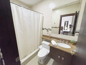 Une salle de bain équipée de toilettes, d’un lavabo et d’un rideau de douche.