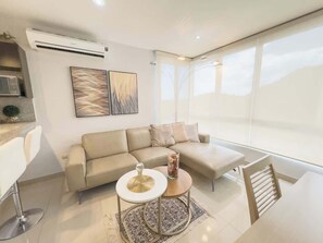 Uma sala de estar moderna com um sofá, uma mesa de centro e uma poltrona.