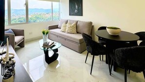 Un salon moderne comprenant un canapé, une table basse, une table à manger et des chaises.