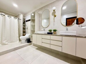 A modern bathroom with a toilet, a sink, a shower, and a large mirror. - Large Apt in Lomas Urdesa • Sleeps 8 • BBQ (Guayaquil)