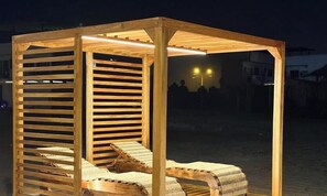 Une structure en bois dotée d’un toit, d’un banc et d’une table.