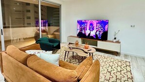 A modern living room with a sofa, a coffee table, and a television. - Luxurious Escape at Santana lofts includes Parking (Guayaquil)
