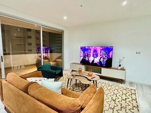 Ein modernes Wohnzimmer mit einer Couch, einem Couchtisch und einem Fernseher.