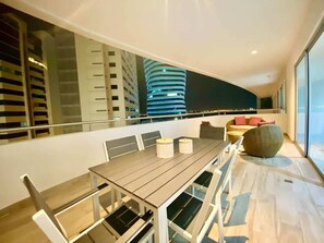 A modern dining area with a long table, chairs, and a view of a cityscape. - Luxurious Escape at Santana lofts includes Parking (Guayaquil)