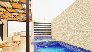 Un intérieur moderne avec une piscine, un plafond en bois et un mur à texture.
