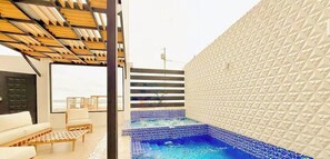 A modern interior with a pool, wooden ceiling, and a textured wall. - Beachfront, pool, whirlpool & firepit (Montanita)