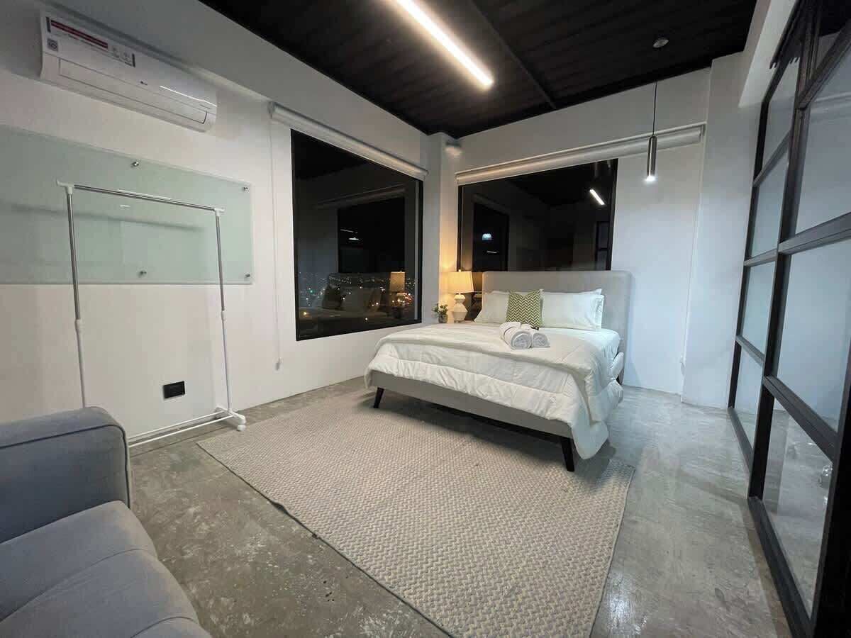 Un dormitorio moderno con una cama grande, un escritorio y una ventana.