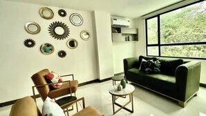 A living room with a sofa, chairs, a coffee table, and wall decorations.