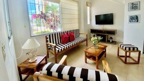 Una sala de estar con un sofá, una mesa de centro y un televisor.