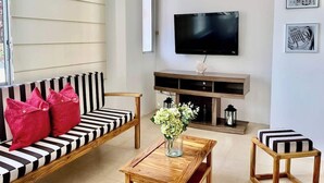 Una sala de estar con un sofá, una mesa de centro, un televisor y una chimenea.