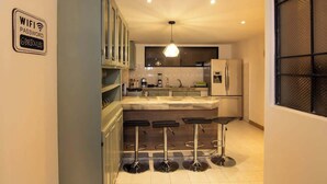 Una cocina moderna con barra, un lámpara colgante y un cartel que indica la contraseña de WiFi.