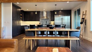 Una cucina moderna con mobili scuri, un'isola centrale e un frigorifero in acciaio inossidabile.