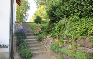 A stone staircase leading up to a house, surrounded by lush greenery and flowering plants. - Awesome home in Röbel with house a panoramic view (Röbel)