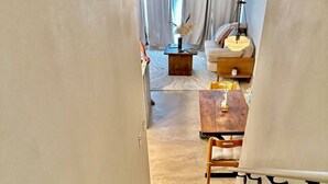 A wooden staircase leading to a living area with a sofa, coffee table, and decorative vase. - One - Too - Suite, Saint George Island, Beach Townhome (Eastpoint)