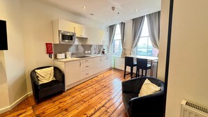 A compact living space with a kitchenette, a dining area, and seating. - Quiet and Modern Studio 201 in Nottingham City Centre- Near Victoria (Nottingham)