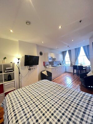 Tabla de planchar con plancha, internet y ropa de cama