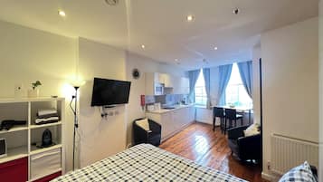 Tabla de planchar con plancha, internet y ropa de cama