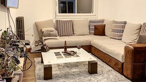 Una sala moderna con un sofá modular, una mesa de centro y una televisión.