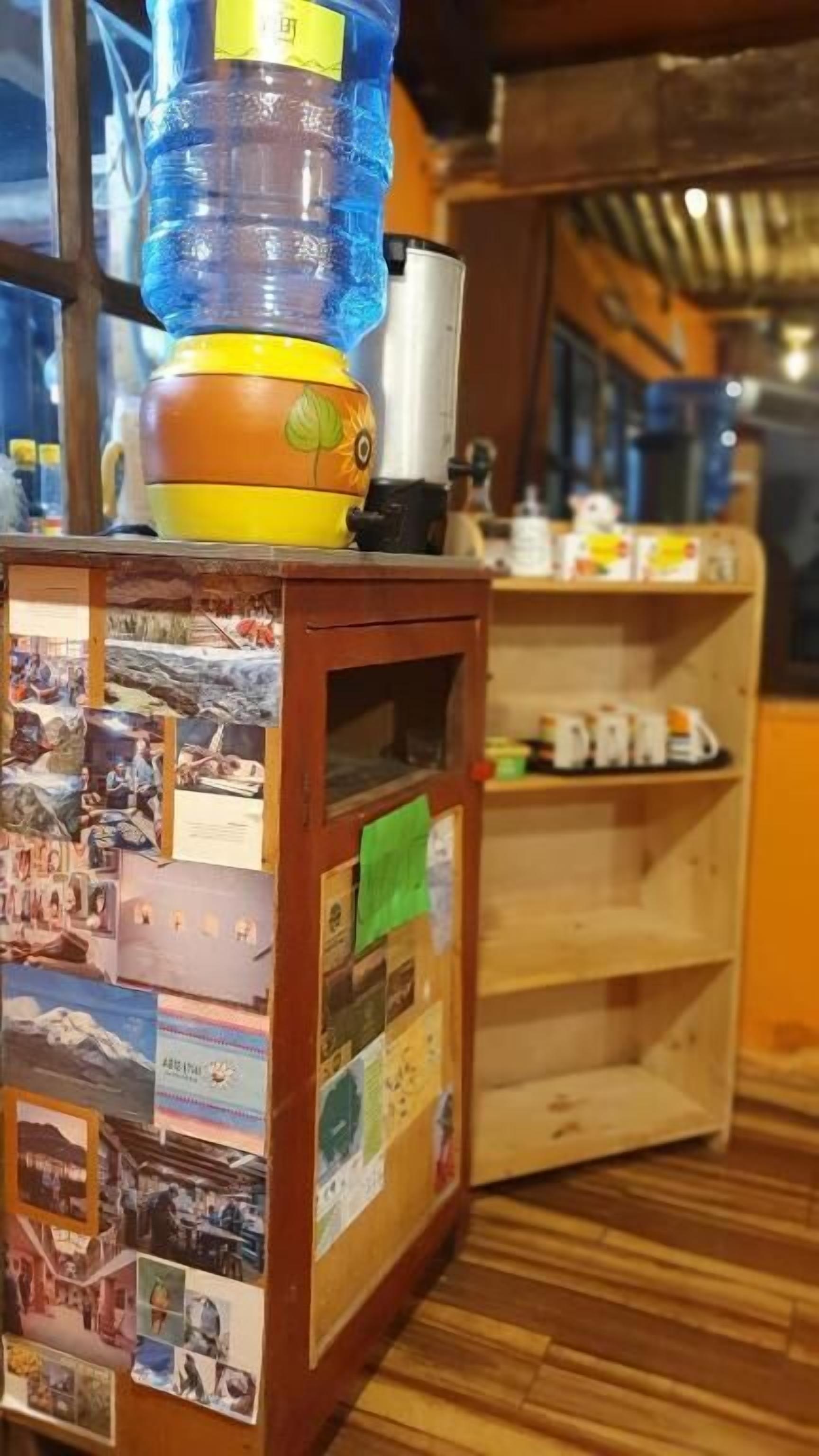 A room with a wooden cabinet displaying photos and a water dispenser on top.