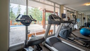 A gym with treadmills, a stationary bike, and exercise balls. - Modern condo at Falcon Crest Lodge with extra amenities (Canmore)