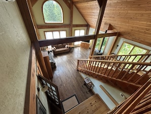 Une pièce de style loft avec un escalier en bois, un canapé et une cheminée.