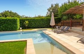 A swimming pool with a tiled deck, a small garden area, and a wooden fence. - Gorgeous home in La Gaude (La Gaude)