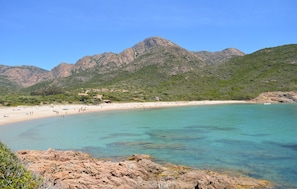A coastal beach with clear turquoise waters, rocky foreground, and a mountainous backdrop. - Nice home in Evisa with private swimming pool, can be inside or outside (Evisa)