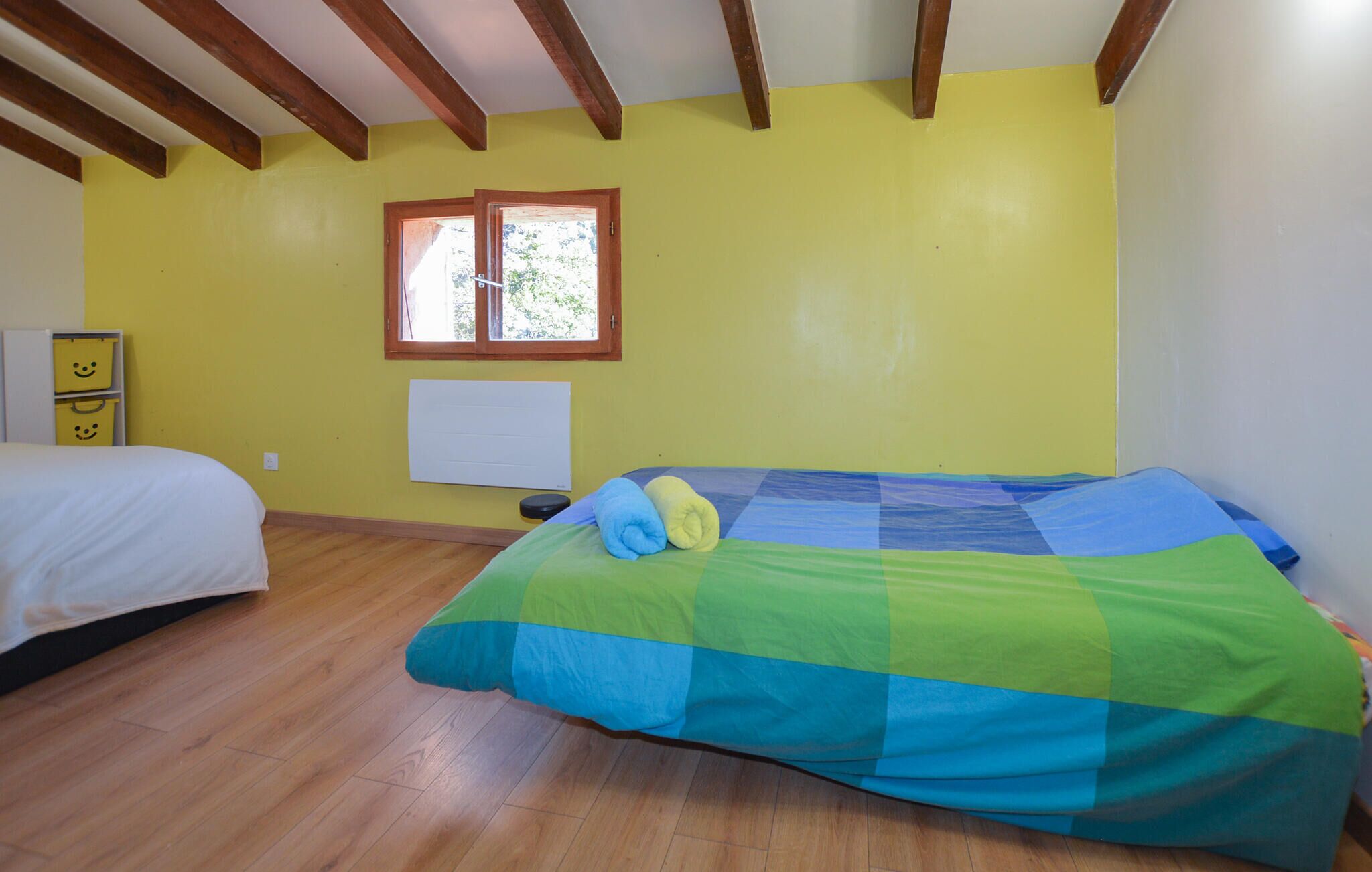 Una stanza con un letto, una finestra e un termosifone.