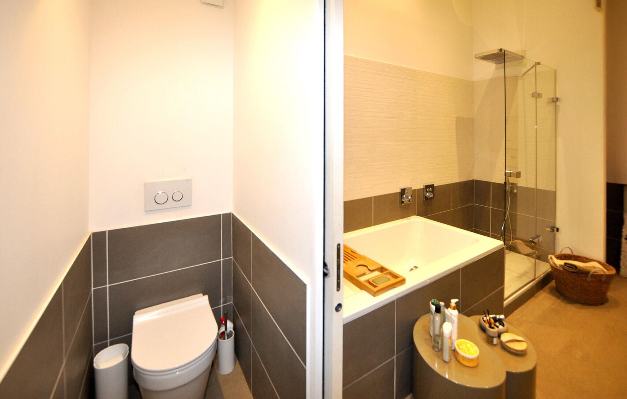 Un baño moderno con inodoro, bañera y ducha.