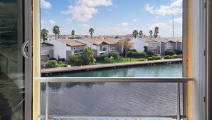 A view of a marina with several houses along the water, featuring a clear sky and calm water. - Cozy apartment in Agde with house sea view (Agde)
