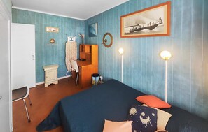 A room with a bed, a desk, a chair, a mirror, and a framed picture on the wall. - Cozy apartment in Agde with house sea view (Agde)