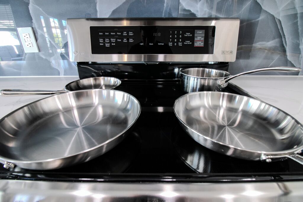 Een keuken met een digitale kookplaat en twee roestvrijstalen koekenpannen.