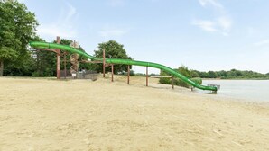 A sandy beach with a green water slide structure. - Beautiful home in Erm with WiFi (Erm)