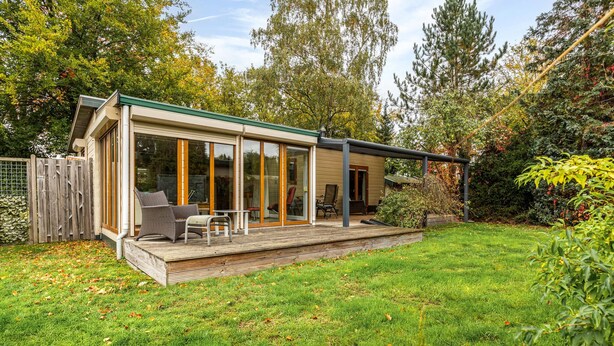 A modern house with a deck, sliding glass doors, and a fenced yard. - Beautiful home in Erm with WiFi (Erm)