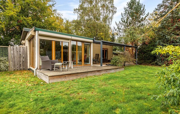 A modern house with a deck, sliding glass doors, and a fenced yard. - Beautiful home in Erm with WiFi (Erm)