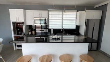 Een koelkast met diepvriezer, een microgolfoven, een oven, een kookplaat