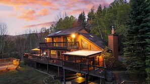 A two-story log cabin with a balcony and deck, surrounded by forest. - Secluded Retreat w/ Pool, Hot Tub, Fire Pit, Views Windham Mountain House (Windham)
