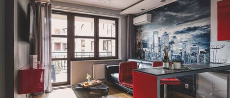 A modern living room with a cityscape mural, a dining area with a bar, and a red cabinet.