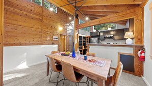 Un interior de madera con una mesa de comedor, sillas, una zona de cocina y un extintor.