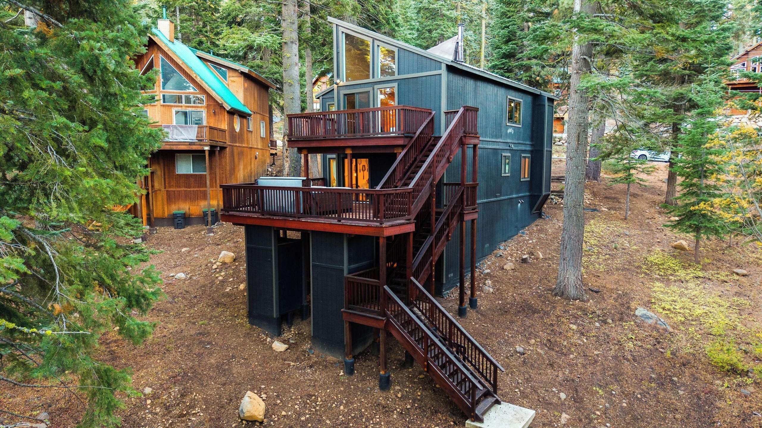 A cabin with a wooden exterior, a balcony, and a staircase.