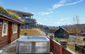 A wooden cabin with a hot tub and a view of mountains. - 3 bedroom beautiful home in Straumgjerde (Straumgjerde)