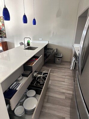Eine moderne Küche mit weißen Schränken, einer eingebauten Spüle und einem Edelstahl-Kühlschrank.
