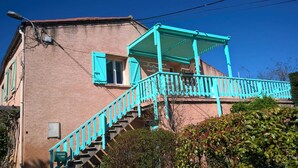 Un bâtiment à deux étages doté d’un balcon et d’un escalier turquoise.