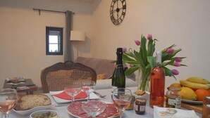 Una mesa de comedor servida con diversos alimentos, copas de vino y una botella de champán.