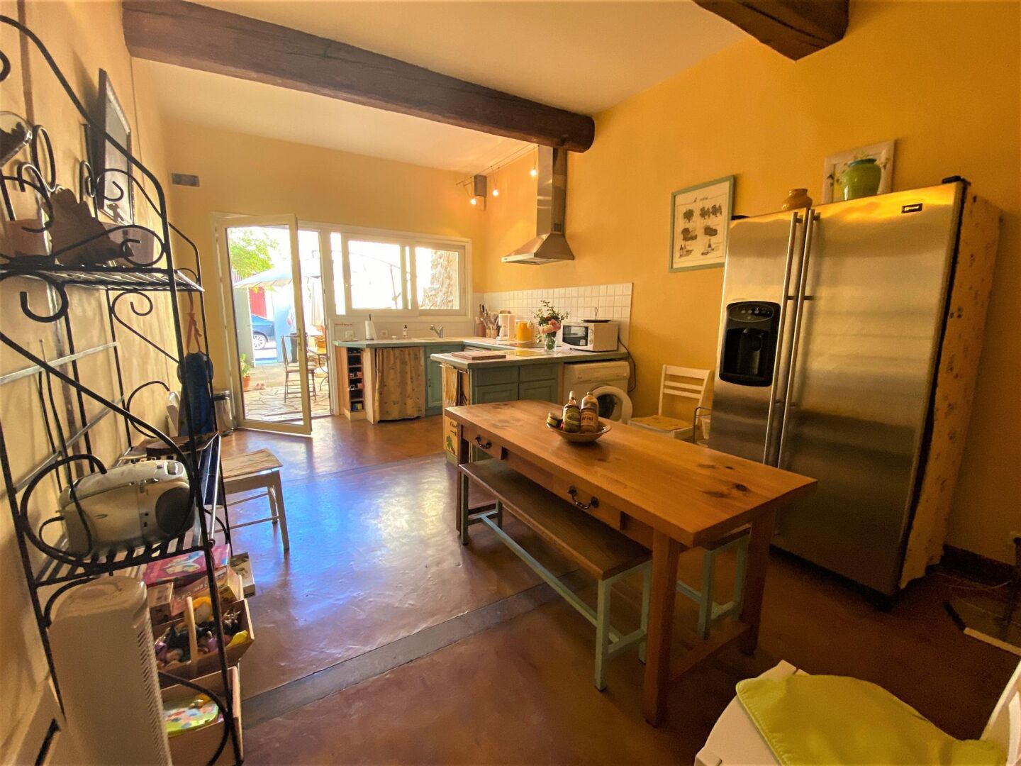 Eine Küche mit Holztisch, Kühlschrank und Spüle.